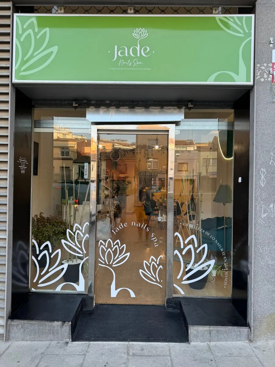 Fachada de Jade Nails Spa con rótulo verde y flor de loto